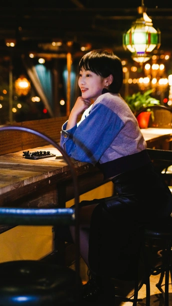 一个坐在餐厅桌子旁微笑着的女人和一个年轻男孩