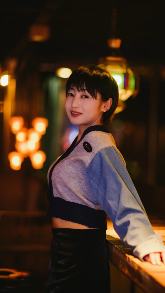 站在一排灯前面的年轻女子