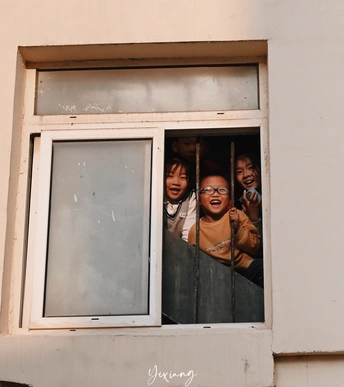 年轻人正在建筑物的窗户旁向外看