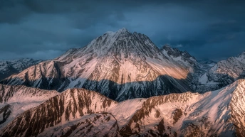 夕阳下 太阳照亮了山脉的雪峰。