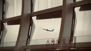 飞机飞越一座带有大型窗户的大楼