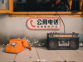 地板上的一台旧电话和收音机 墙上挂着一张标签