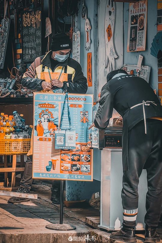 一位在商店工作的男子正在街上看某物