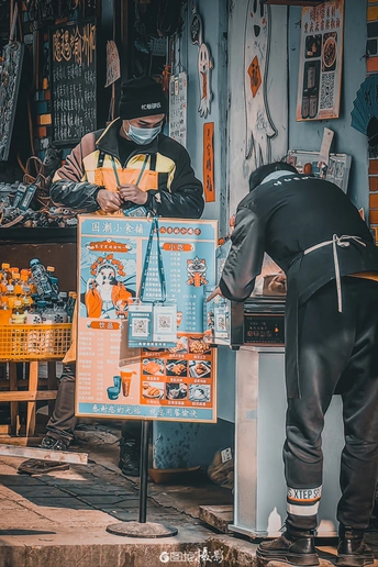 一位在商店工作的男子正在街上看某物