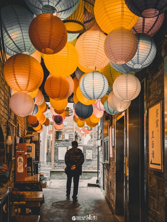 一个人走过一个挂满灯笼的狭窄小巷