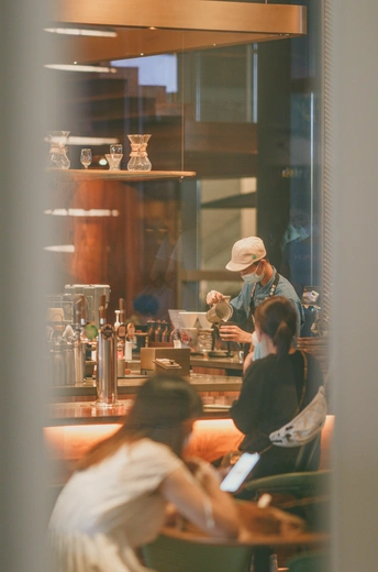 有人坐在桌子旁 柜台后面有一个人的餐馆