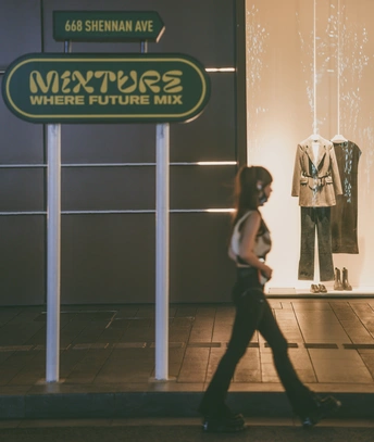 一个年轻女孩在街上的一个人体模型前走在人行道上