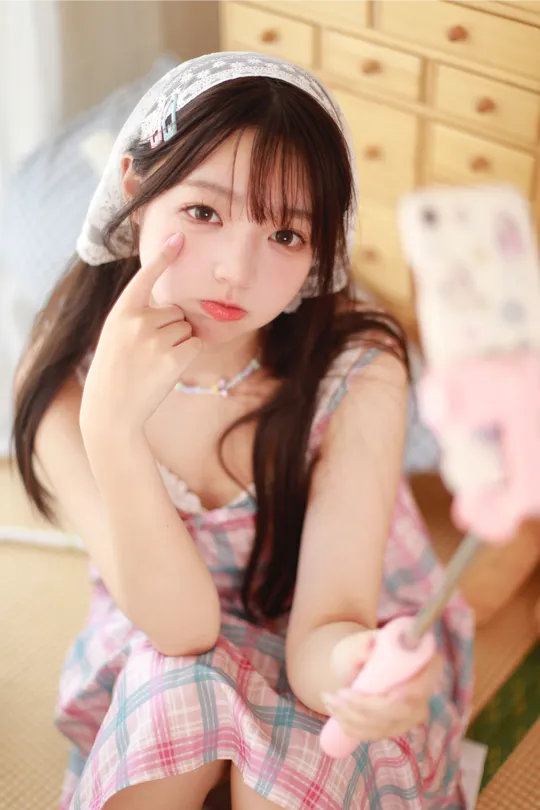 一位穿着连衣裙的年轻女子手里拿着一小块蛋糕