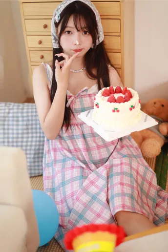 一位穿着连衣裙的年轻女子拿着蛋糕