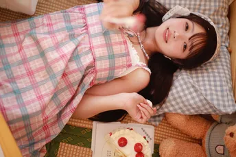 一位年轻女子抱着一个小女孩躺在地板上 旁边放着一只泰迪熊和生日蛋糕。