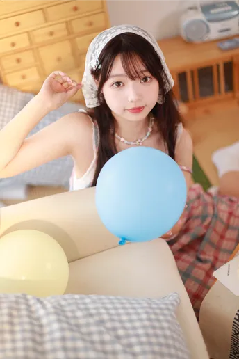 一个年轻女子坐在床上抱着一个蓝色气球