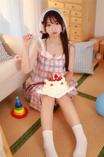 一个小女孩穿着裙子 手里拿着一盘蛋糕