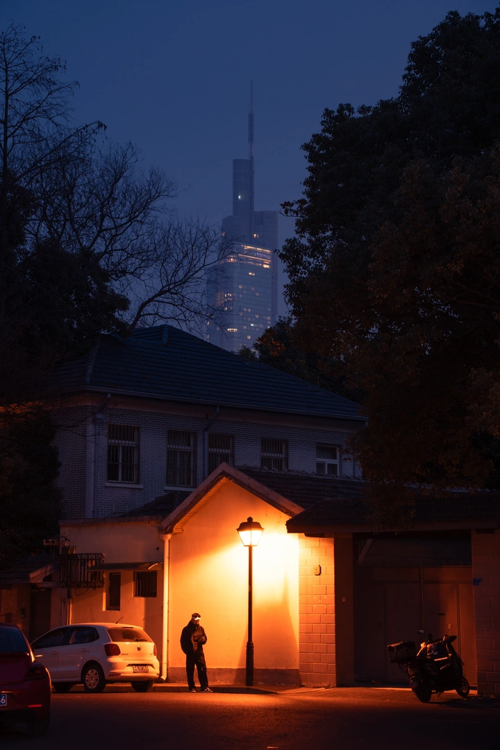 夜晚路灯下路人与紫峰大厦的合影