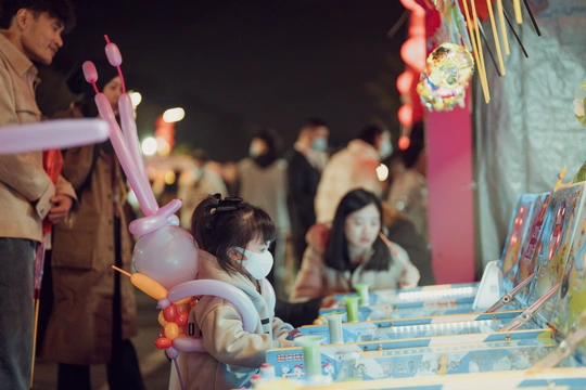 一位年轻女子站在一张桌子旁边 桌子上有一个洋娃娃 人们正在桌子上的玩具。