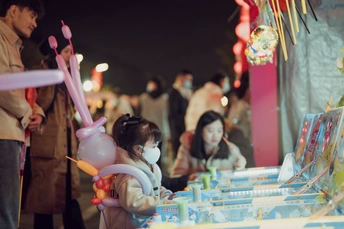 一位年轻女子站在一张桌子旁边 桌子上有一个洋娃娃 人们正在桌子上的玩具。