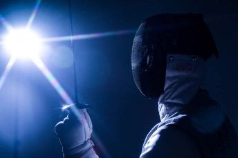 戴面具的人挥舞着剑在黑暗中