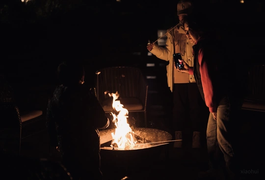 夜晚站在火堆旁的人们