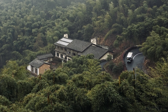 一辆汽车驶过一条被小屋环绕的山间小路