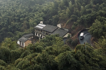 一辆汽车驶过一条被小屋环绕的山间小路