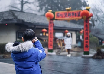 一位穿蓝色夹克的女人在打电话 一位穿蓝色夹克的男人在雨中站在寺庙前