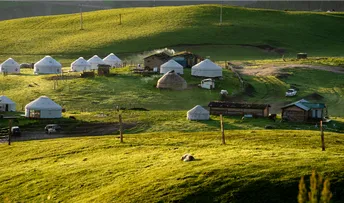 一片绿草地 帐篷为白色 背景为村庄