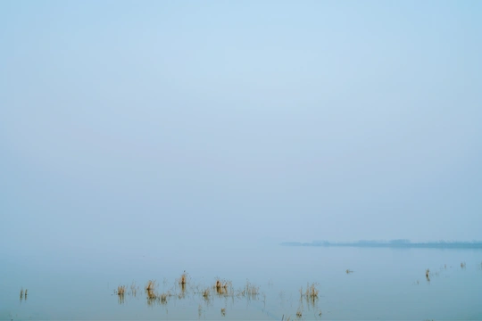 湖上的一艘船在蓝天下的雾中
