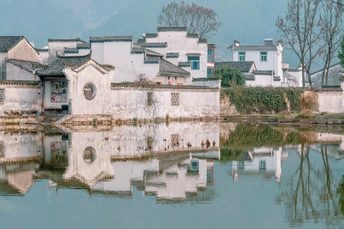一个小村庄 有白色的建筑 它们在水中的倒影 水体看起来像一条河。