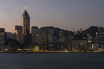 暮色或日落时分的城市 摩天大楼被点亮 前景中有一片水域。