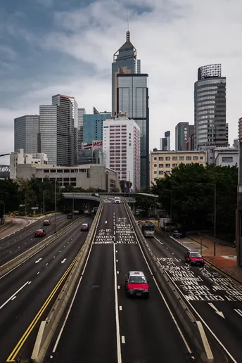 中间有高楼大厦和汽车在高速公路上行驶的城市