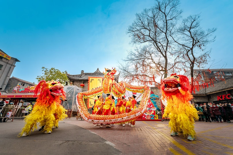 一群穿着戏服的人在节日游行中走下街道