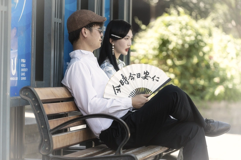 一个人和一个女人坐在公交车站的长凳上