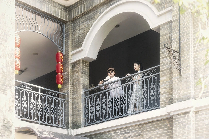 一个人和一个女人站在一栋建筑物的阳台上