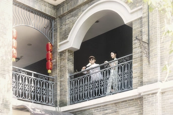 一个人和一个女人站在一栋建筑物的阳台上