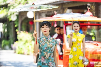 一位穿着花裙子的年轻女子打着伞走在街上