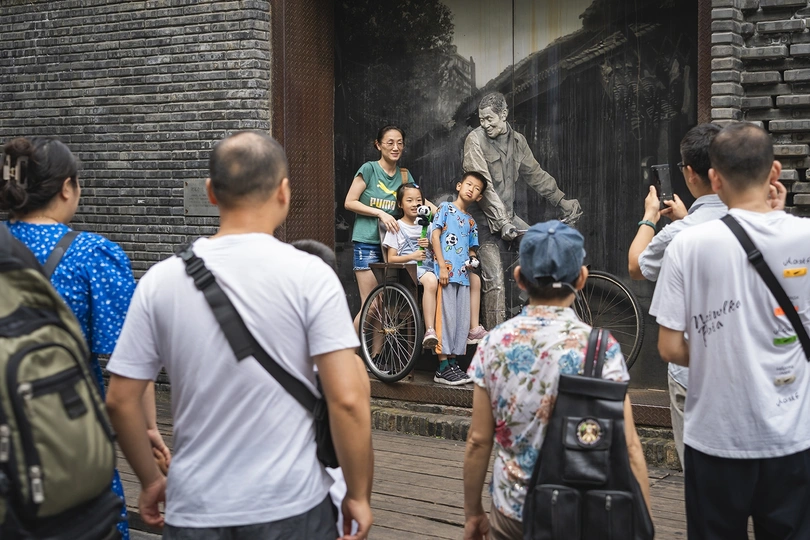 人群正在拍照 照片中的人物是一座雕像。