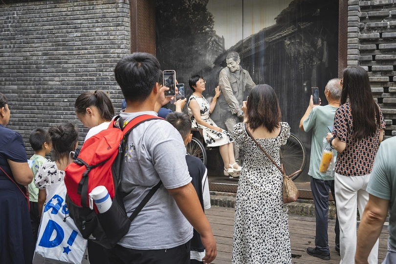 人群站在街上拍照 雕像