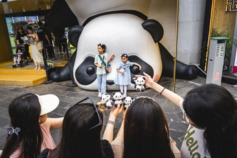 人们在大型熊猫前拍照