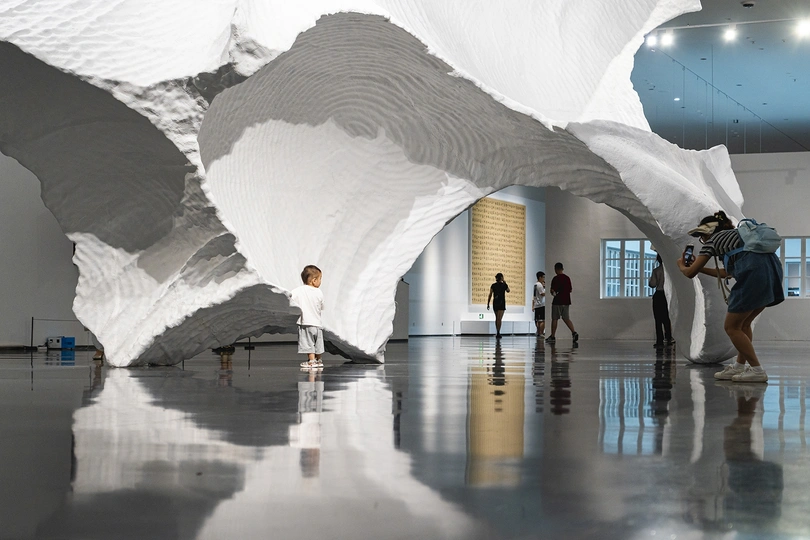 一群人在博物馆里看着一件白色雕塑