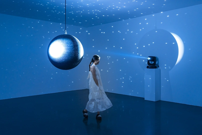 一个穿白裙子的女人在一个被蓝色灯光照亮的房间里