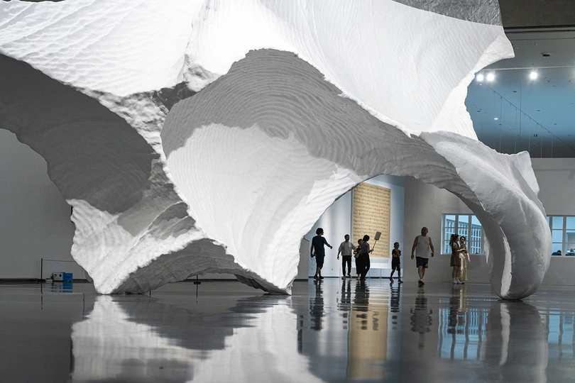 一群人在博物馆里看着一件白色雕塑