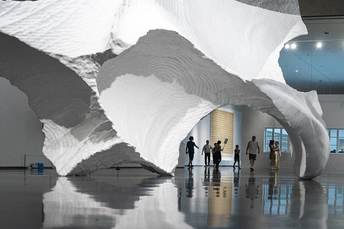 一群人在博物馆里看着一件白色雕塑