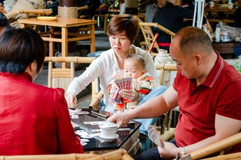 一个坐在桌子旁 婴儿坐在红色椅子上 一个男子在餐厅用餐的女人。