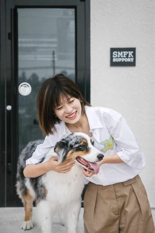 一位年轻女子抱着一只狗在进行拍照拍摄