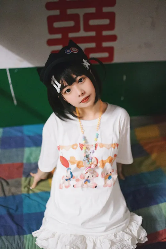 一个小女孩穿着白色衬衫和帽子站在床上