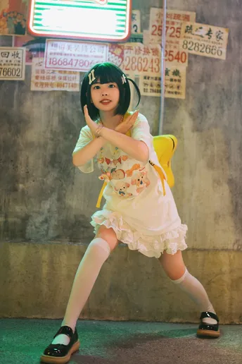 一个小女孩穿着黄白色连衣裙在街上