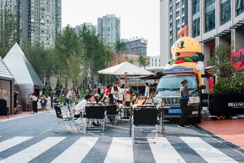 人们在街中央的桌子旁坐着