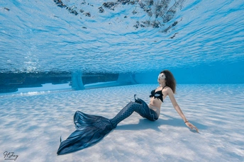 一位穿着蓝色比基尼的年轻女子在水池中