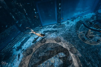 一位女士在浴室的蓝色水中游泳