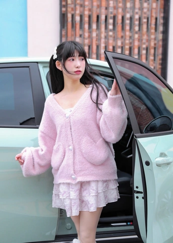 一个穿粉红色皮草的女孩站在汽车门旁边