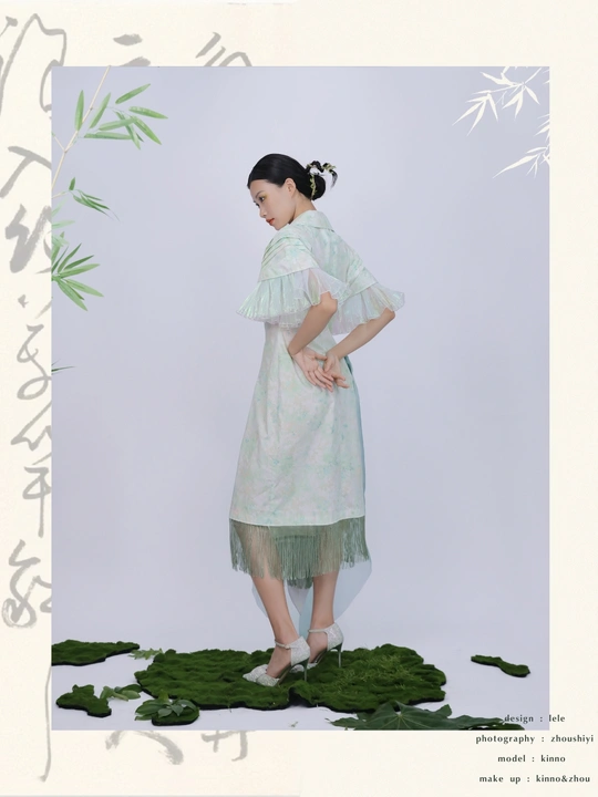 一位穿着白色连衣裙的年轻女子站在绿叶背景前